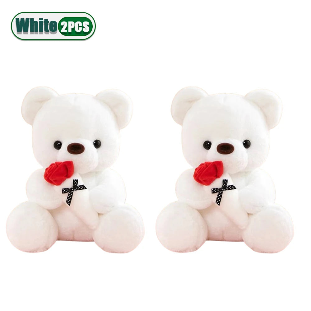 A pair of white bear plush toys with red faux flowers on their chests.