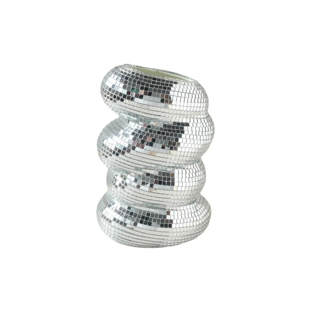 A spiral disco ball made of silver mosaic tiles used as a vase or pen holder.