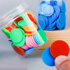 A clear plastic container filled with colorful plastic counting chips in various shades of green, pink, orange, and blue.