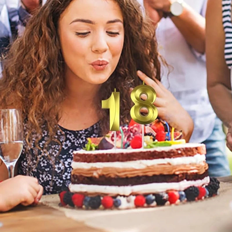 A close-up of a layered cake decorated with gold numbers 1 and 8 for a birthday celebration.