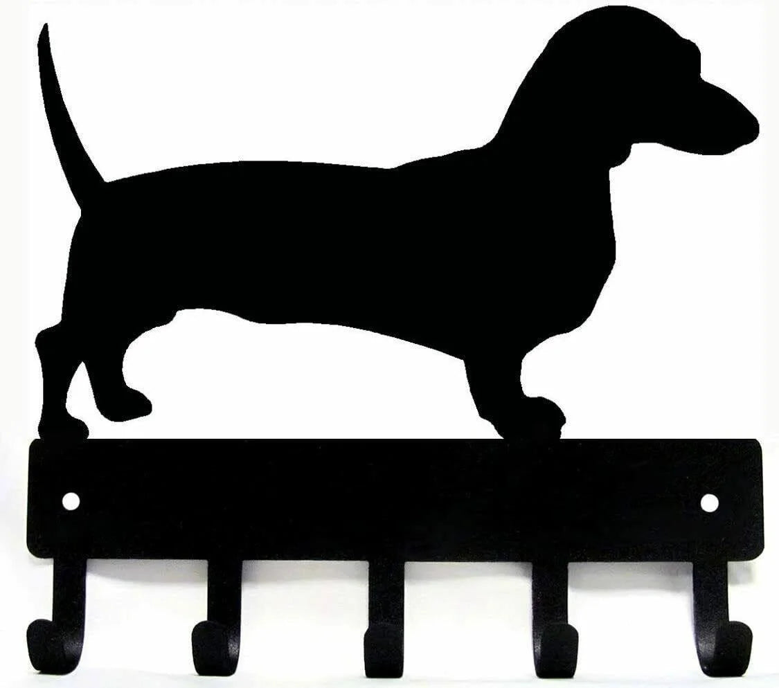 Black silhouette of a dog standing on decorative metal key hooks for wall organization