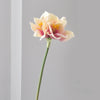 A single pale yellow and pink artificial clivia amaryllis flower on a green stem.