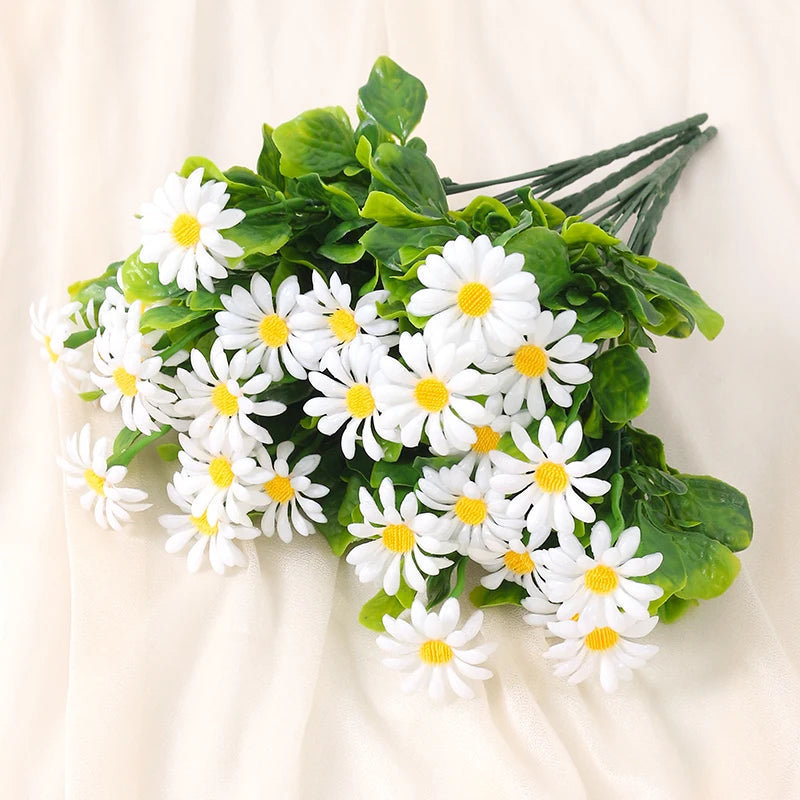 A bouquet of white daisies with green leaves arranged for home decor or events.