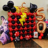 A large arrangement of gold and black foil balloons shaped like the number 5, used for Las Vegas party decor.