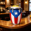 A silver drum-style can holder with a patriotic red white and blue design sits on a wooden bar counter.