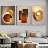 Three modern geometric canvas wall art pieces featuring abstract shapes in gold, bronze, and charcoal tones.