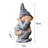 A small, gray gnome statue with a pointed hat and chubby face, shown from the side.