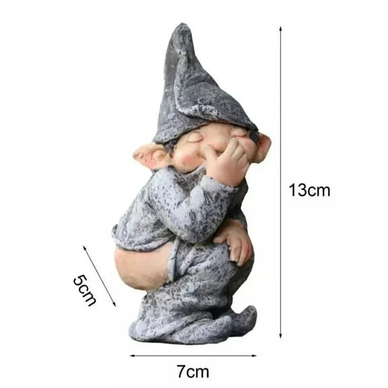 A small, gray gnome statue with a pointed hat and chubby face, shown from the side.