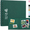 A dark green spiral-bound notebook with a heart design, showing pages and sheets.