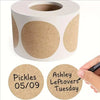 A white cylindrical paper seal label dispenser with round kraft paper labels showing the date 05/09 and the word Tuesday.