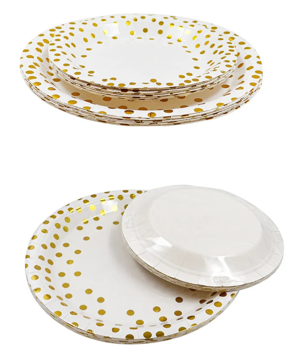 A stack of elegant white and gold polka dot disposable party tableware plates.