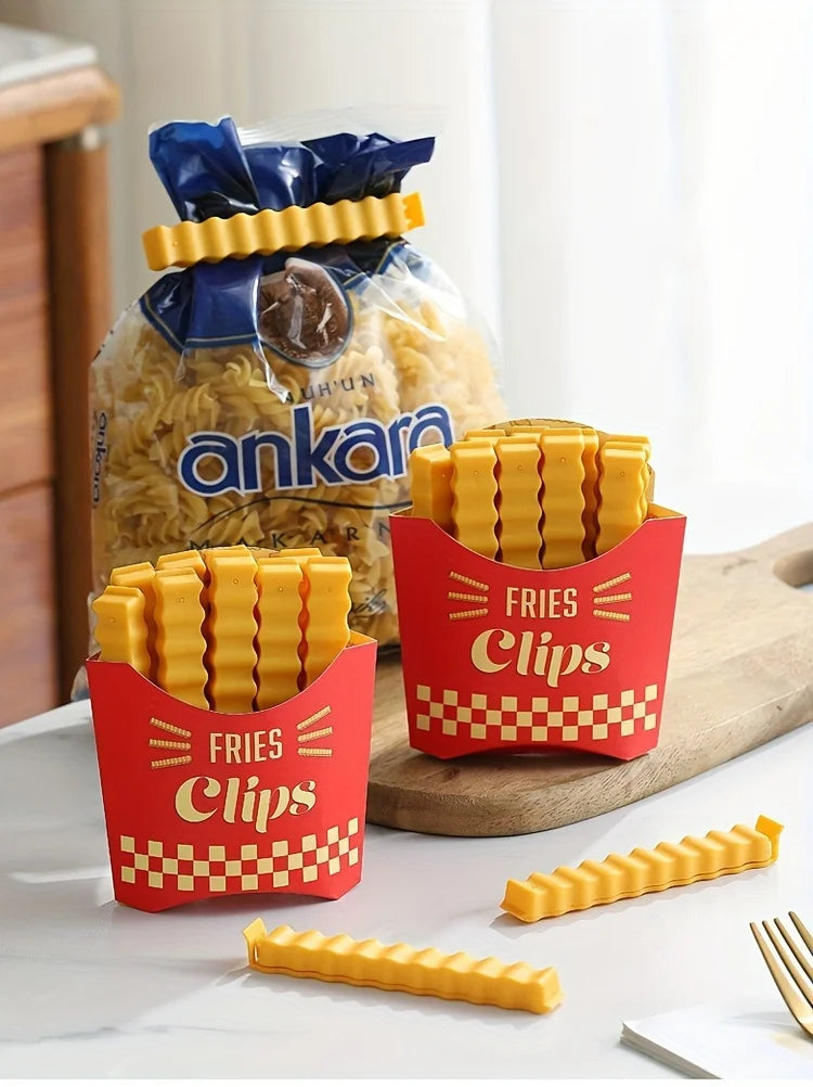 A red container of yellow french fry shaped sealing clips is displayed next to a bag of crispy fried snacks.