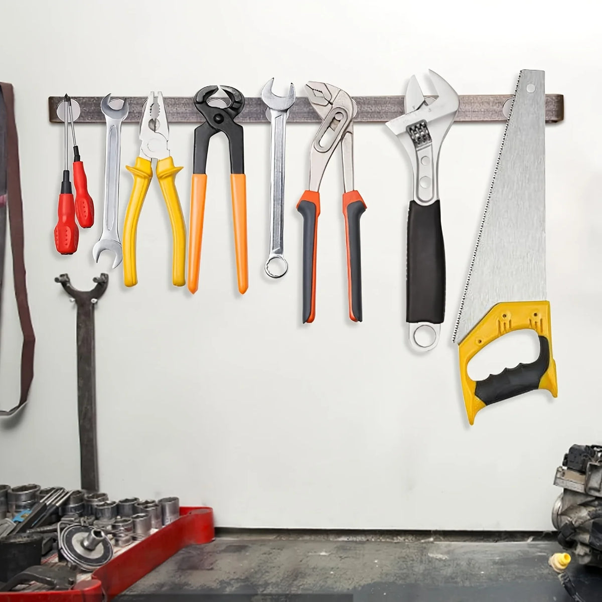 A collection of various hand tools including pliers, wrenches, and a utility knife are displayed on a wooden rack.