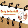 A close-up of black weatherproof outdoor light string clips being installed on a brown surface.