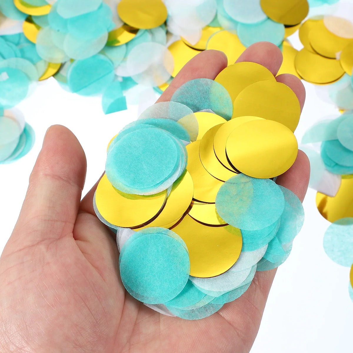 A hand holds a cluster of round tissue paper confetti dots in shades of yellow and light blue.