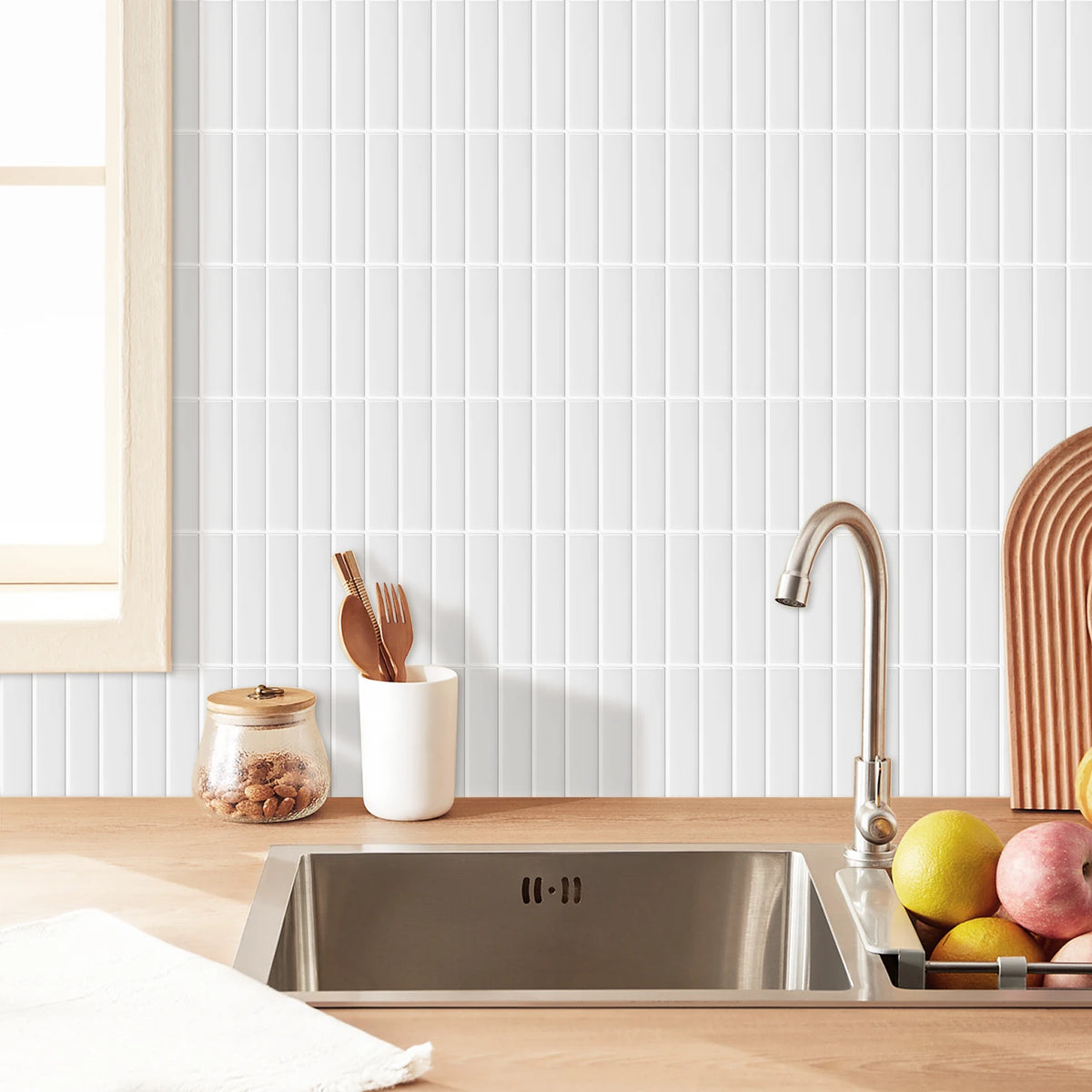 A stainless steel kitchen sink is placed on a wooden countertop in front of a white tiled backsplash.
