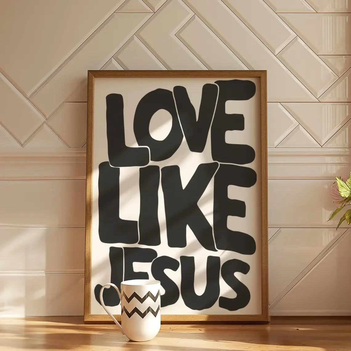 Framed black text saying Love Like Jesus on a canvas print displayed on a wooden floor.