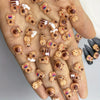 Eine Hand zeigt verschiedene gemischte Cartoon-Tier-Nageldekorationen auf den Fingernägeln.