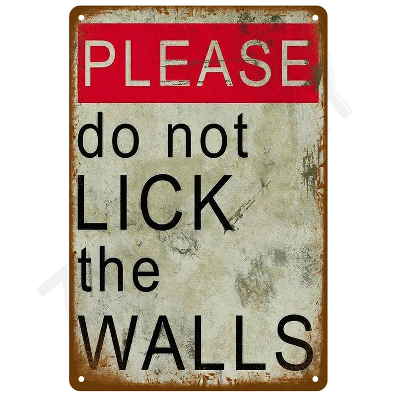 A vintage tin sign with red text reading PLEASE do not LICK the walls on a weathered gray background.