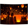 A dark night scene filled with numerous glowing orange lanterns illuminating a crowd.