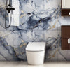 A modern toilet is set against a marble peel-and-stick wall panel featuring gray and black veining with gold accents.