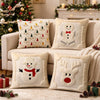 A collection of cream-colored Christmas pillows featuring white snowman and reindeer designs with red accents.
