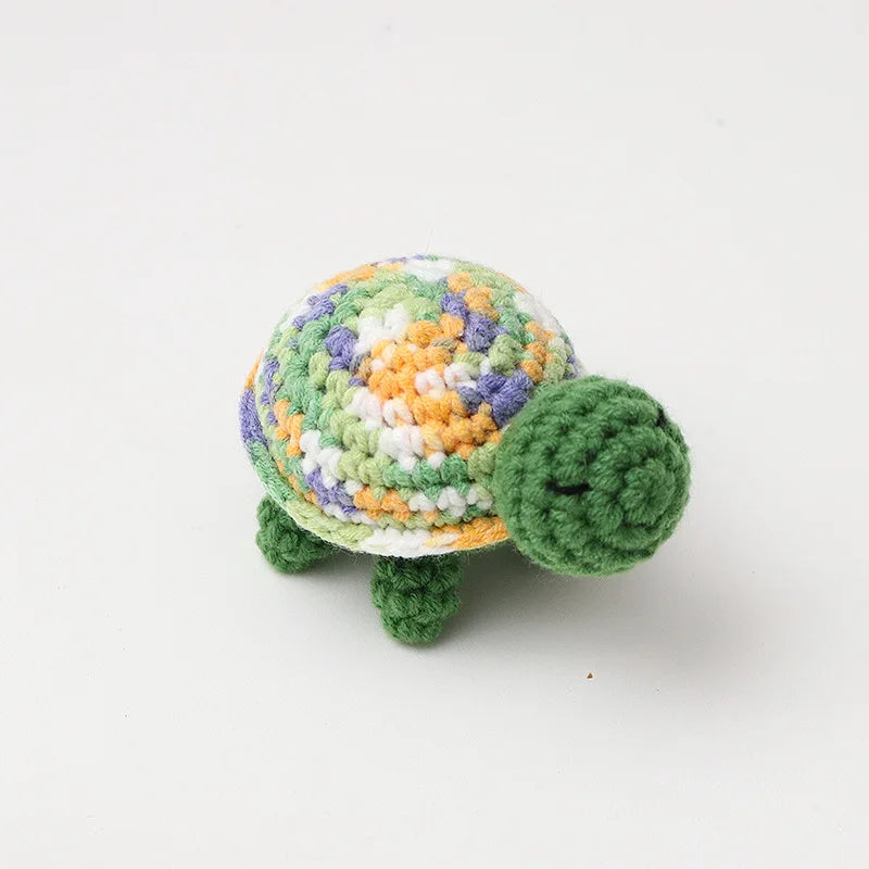 Handmade crocheted turtle plush with a mottled green and yellow shell.
