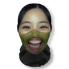 A close-up of a woman wearing a green carnival mask with visible teeth and dark hair.