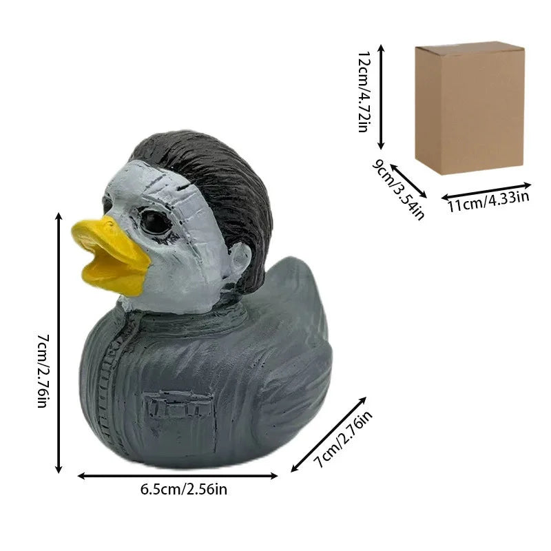 A gray resin figurine of a duck with a yellow beak and black feathers, packaged in a cardboard box.