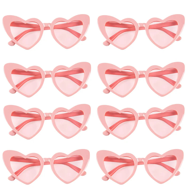 Pair of pink heart-shaped party sunglasses with pink frames and orange tinted lenses