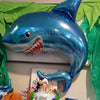 A large blue shark foil balloon decoration used as an ocean-themed party item.