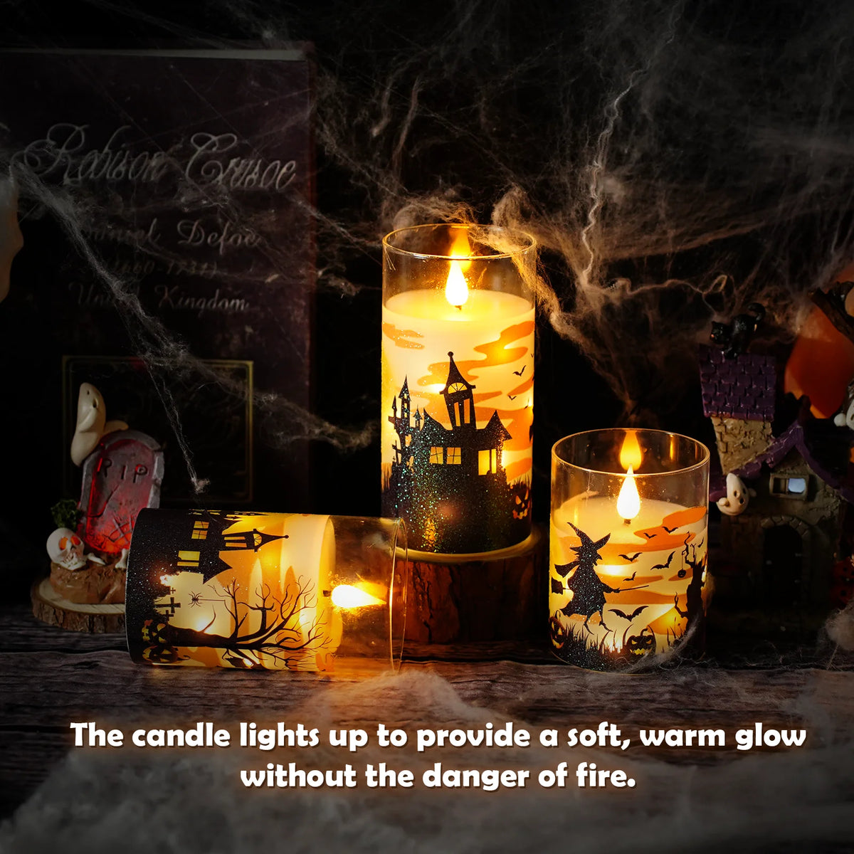A collection of glowing pillar candles in glass holders creating a warm, atmospheric Halloween light display.