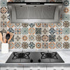 A stainless steel kitchen range hood installed above a tiled backsplash.