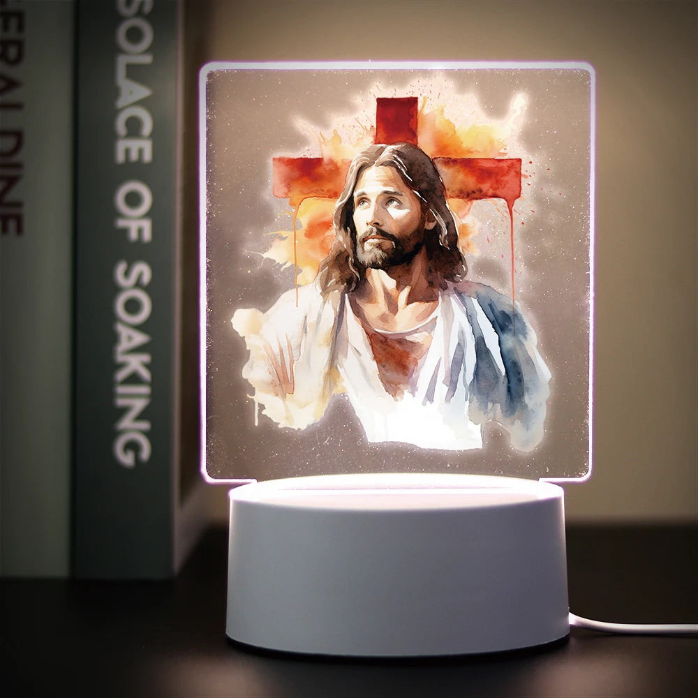 A glowing LED night light displays a painting of Jesus with a cross and flowing paint effects.