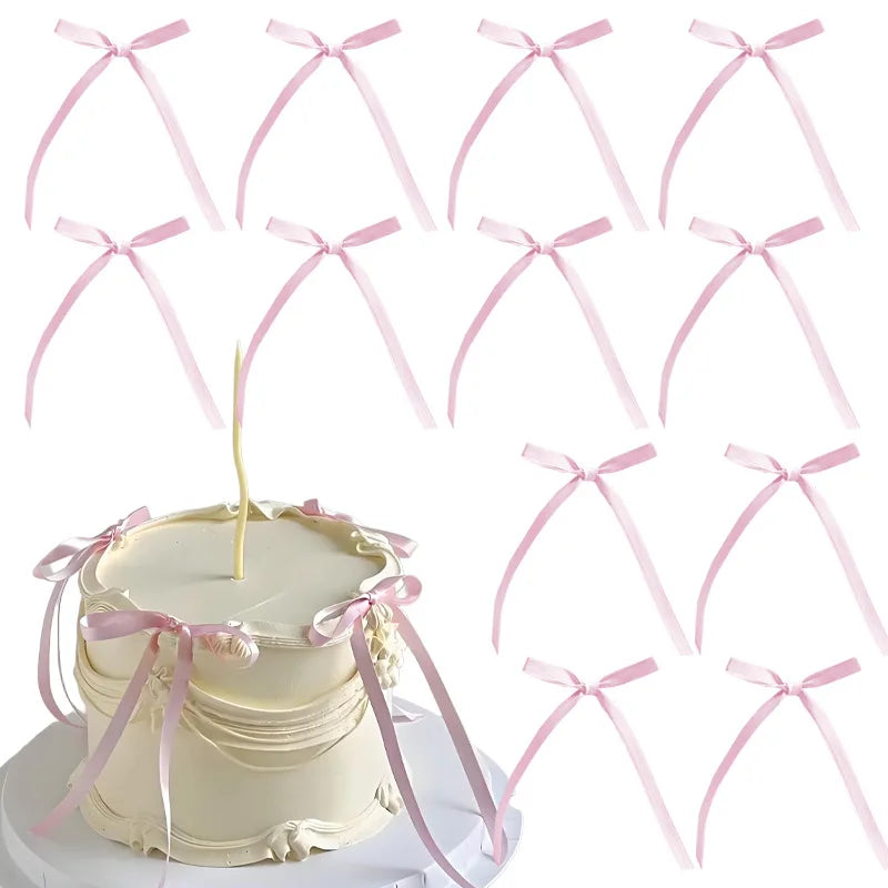 A set of pink bowknot ribbon cake toppers for birthday and wedding cakes displayed around a white cake.