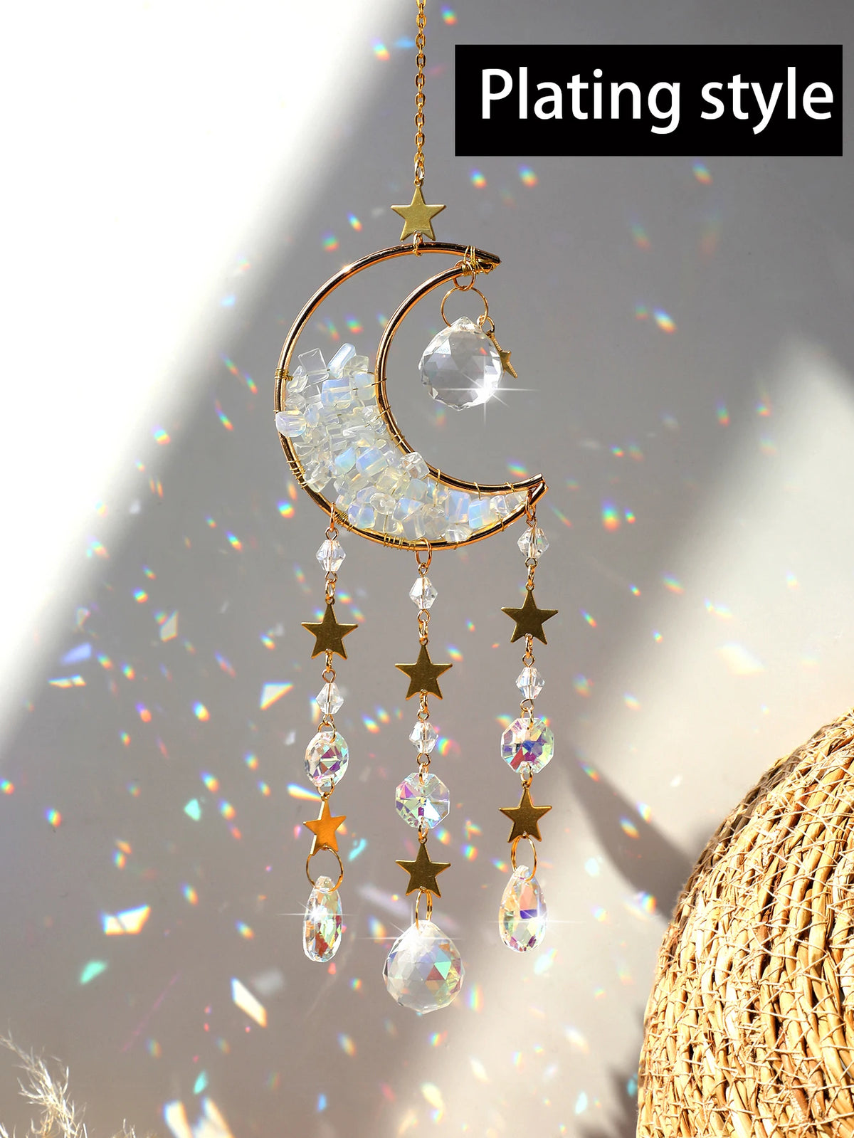 A handcrafted gold moon crystal suncatcher with a prism pendant hanging against a bright background.