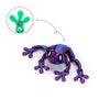 A purple articulated 3D printed frog magnet with green details, showing its movable limbs.