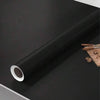 A roll of matte peel and stick decor stickers shown against a dark surface.