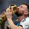 Leyenda del fútbol Lionel Messi sosteniendo un trofeo dorado con la boca, celebrando en el campo.