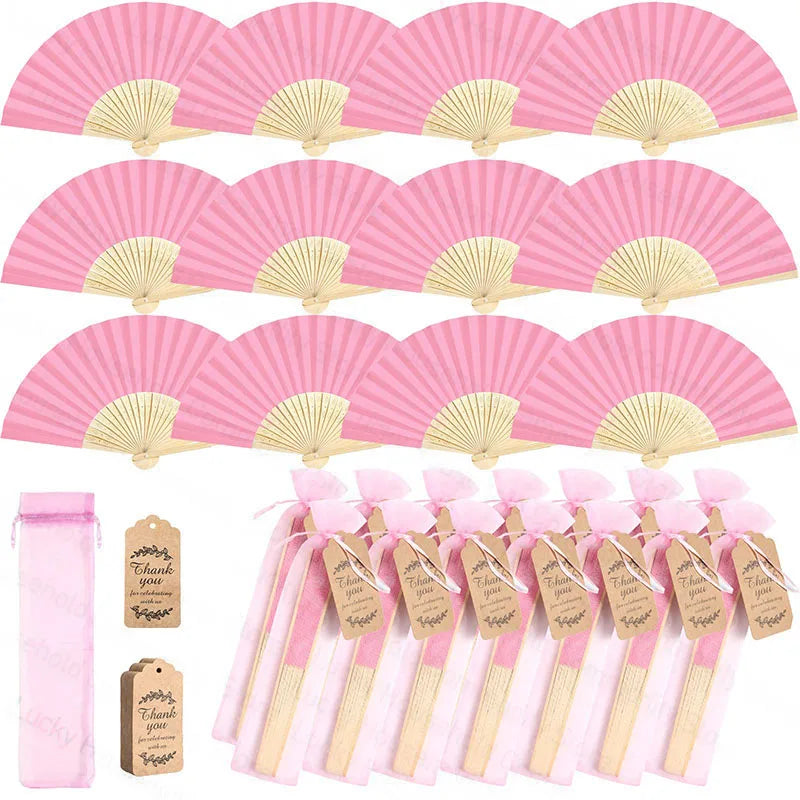 Pink paper hand fans with gold accents packaged in gift bags and thank you cards