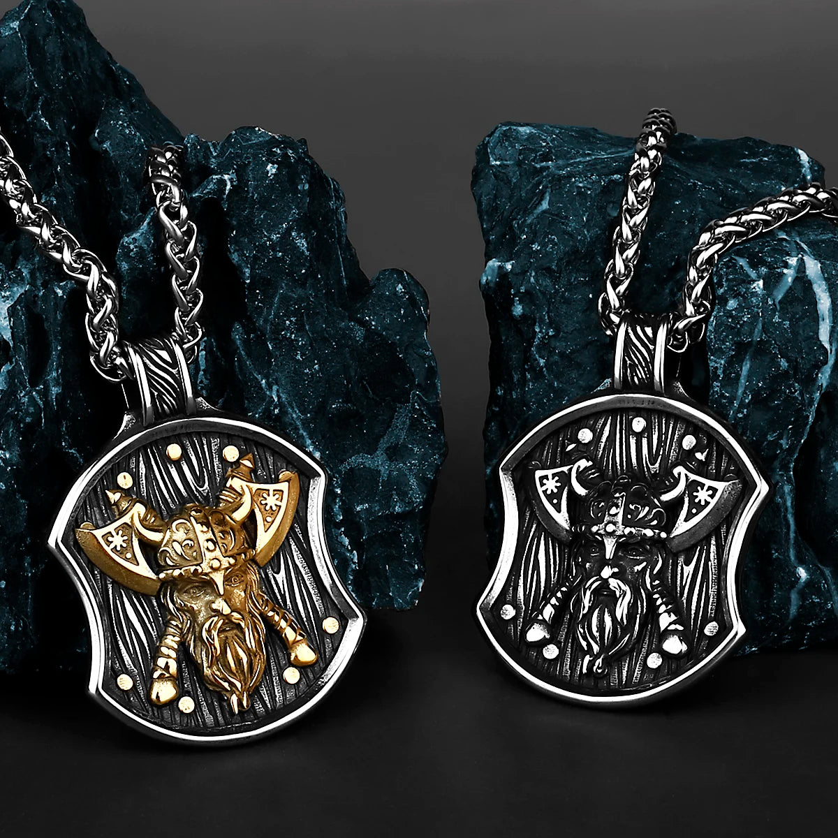 A silver stainless steel necklace featuring a Viking warrior shield pendant hanging from a chain against a dark blue rock.