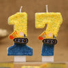 Two yellow construction excavator shaped candles with glittery number seven on blue bases