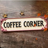 A vintage metal sign with the words COFFEE CORNER and decorative stars on a rustic wooden surface.