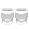 A pair of white stackable spherical ice molds for whiskey and cocktails.