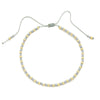 Handmade boho glass bead bracelet with adjustable cord featuring small gold and gray beads.
