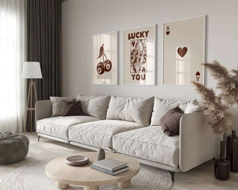 A modern living room features a light sofa, wooden coffee table, and framed art prints on the wall.