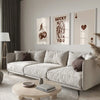 A modern living room features a light sofa and wooden coffee table with framed retro letter art canvases on the wall.
