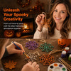A woman is crafting an orange wooden spider web ornament with her hands in a warm, indoor setting.