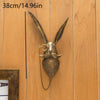 A metallic deer head storage hook wall decor with long ears and a mustache hanging on a wooden panel.