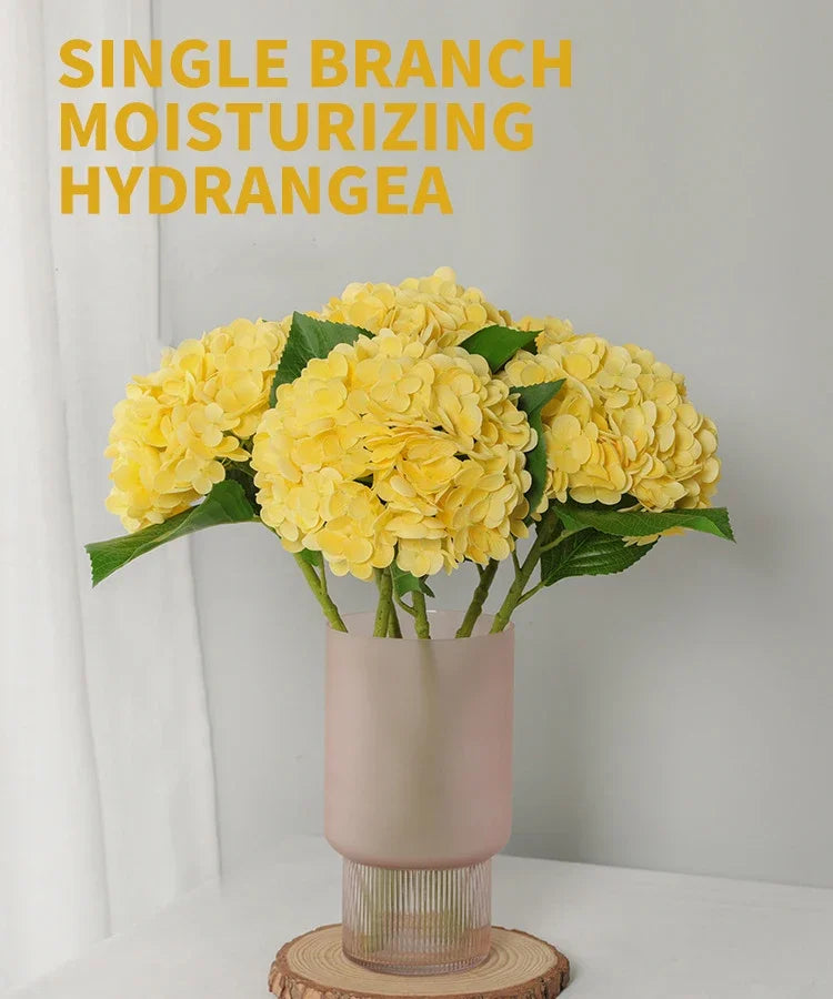 A bouquet of yellow single branch moisturizing hydrangea flowers in a pink vase